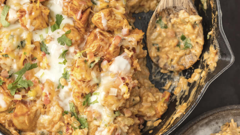 Une poêle de poulet con queso avec une cuillère en bois